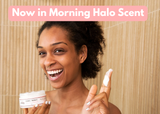 Woman holding a jar of cream with text 'Now in Morning Halo Scent' in a bathroom setting.