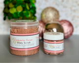 Two jars of Cashmere Cocoa Body Scrub with decorative ornaments in the background.