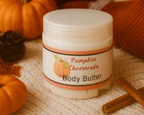 Jar of pumpkin cheesecake body butter with pumpkins and a candle in the background