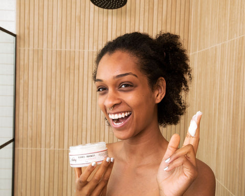 Woman holding natural hair conditioner in shower - make it classy beauty